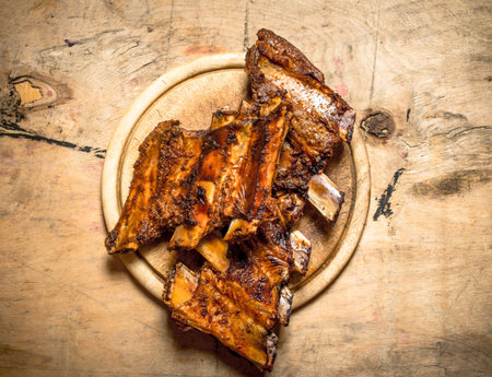 Barbecue pork ribs on the Board. On wooden background.の写真素材