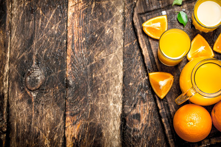 Fresh juice from ripe oranges. On wooden background.の写真素材