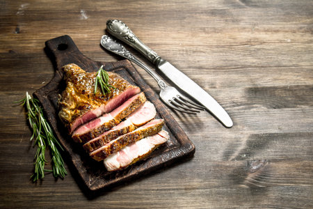 Beef grill with spices on a cutting Board. On a wooden table.の写真素材