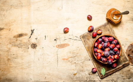 Fresh plum pulp in a glass jar. On wooden background.の写真素材