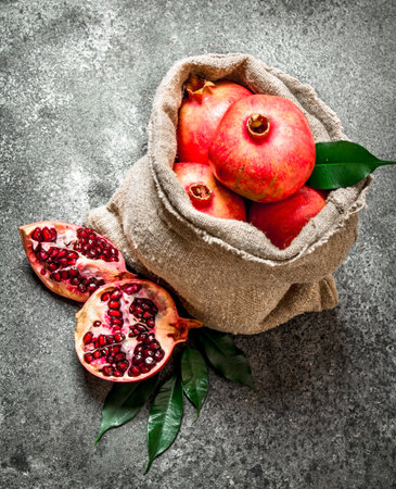 Pomegranates in the old bag. On rustic background.の写真素材