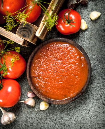 Tomato sauce with spices and garlic in a bowl. On rustic background.の写真素材