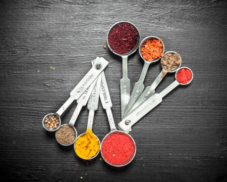 Ground spices in measuring spoons. On the black chalkboard.の写真素材