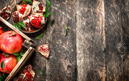 Fresh pomegranates in an old box. On a wooden background.の写真素材