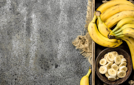 Pieces of fresh bananas in a bowl on a tray. On a rustic background.の写真素材