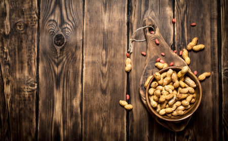 Peanuts in a wooden bowl . On wooden background.の写真素材