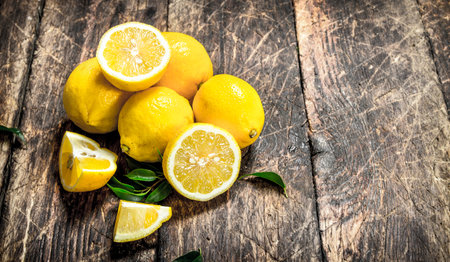 Fresh lemons with leaves. On a wooden background.の写真素材