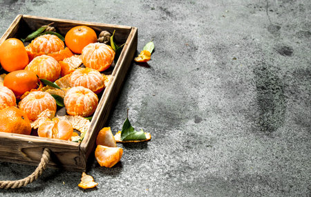 Fresh tangerines on a wooden tray. On a rustic background.の写真素材