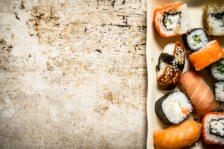 The rolls and sushi, seafood on the plate. On rustic background.の写真素材