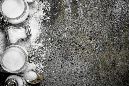 Salt in jars and spoons. On rustic background.の写真素材