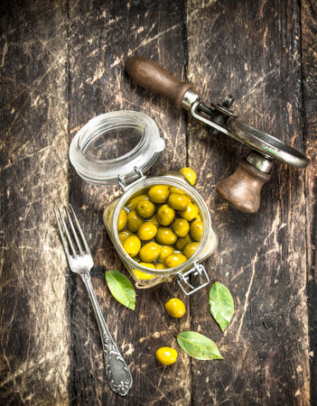 Marinated olives with seamer. On a wooden background.の写真素材