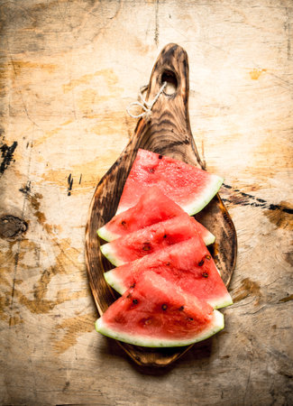 Sliced pieces of watermelon on the Board. On wooden background.の写真素材