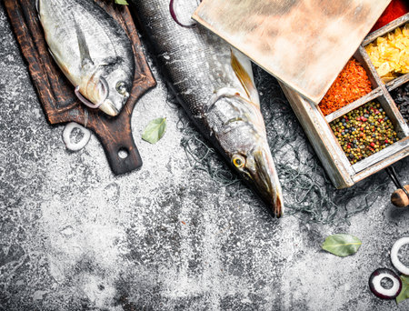 Fresh unprepared fish with spices. On a rustic background.の写真素材