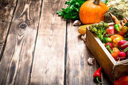 Healthy food. Organic vegetables in an old box. On wooden background.の写真素材