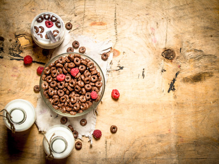 Healthy food. Chocolate cereal with raspberries and milk. On wooden background.の写真素材