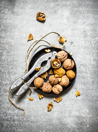 Walnuts in bowl with Nutcracker. On the stone table.の写真素材
