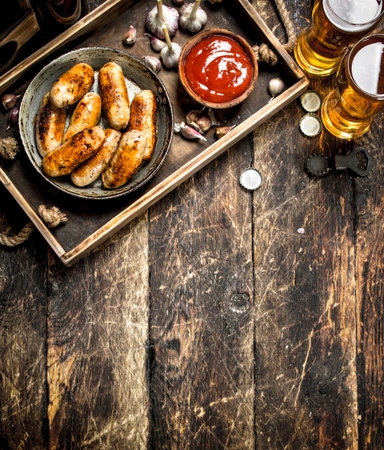 Hot sausages with cold beer. On a wooden background.の写真素材