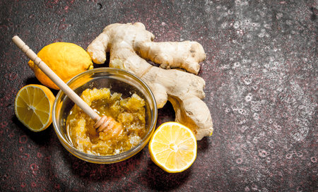Fresh honey with ginger and lemon. On rustic background.の写真素材