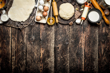 Dough background. Fresh dough with various ingredients on a wooden table.の写真素材