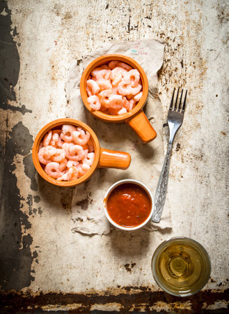 Peeled shrimp with tomato sauce. On rustic background .の写真素材