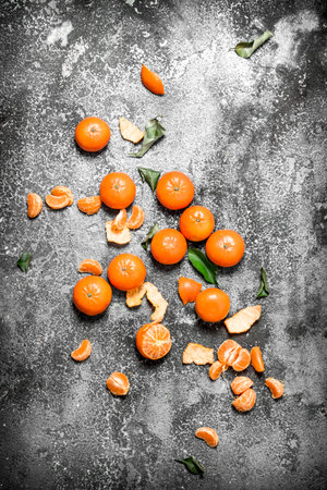 Ripe tangerines with green leaves. On rustic background.の写真素材