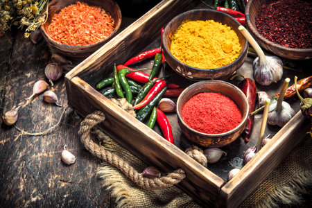 Various ground spices and herbs in an old tray. On a wooden background.の写真素材