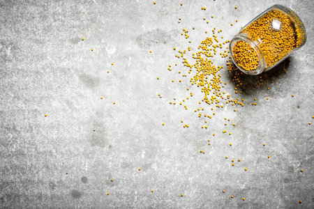 Mustard seeds in glass jar. On the stone table.の写真素材