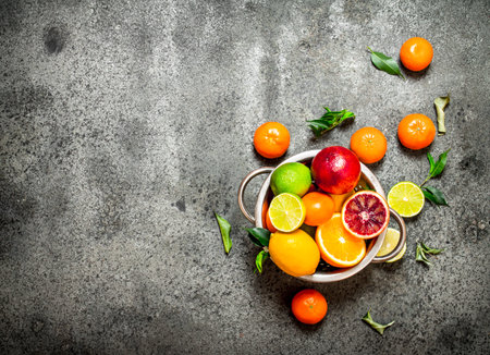 Fresh citrus fruit in a bowl. On rustic background .の写真素材