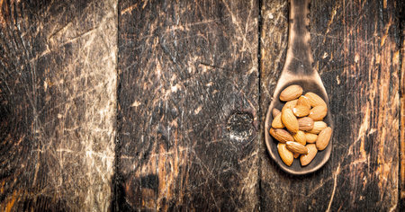 Almonds in a wooden spoon. On wooden background.の写真素材