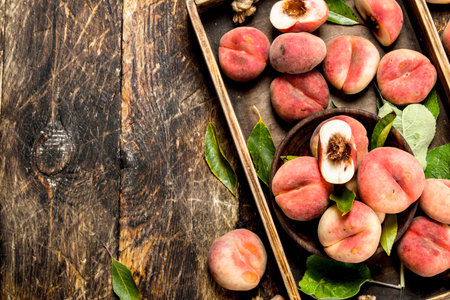 Ripe peaches on a tray. On a wooden background.の写真素材