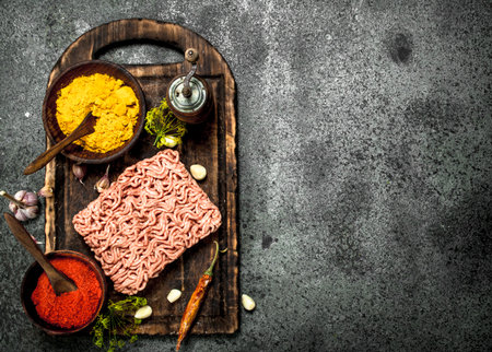 Meat stuffing with spices and herbs on a wooden board. On a rustic background.の写真素材