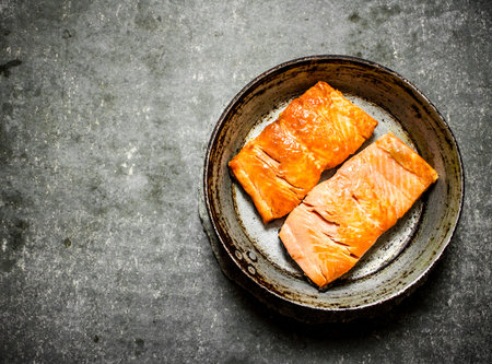 Trout fillet fried in the pan. On the stone table.の写真素材