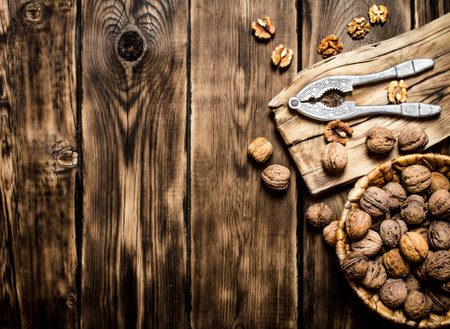 Walnuts with Nutcracker on the Board. On a wooden table.の写真素材