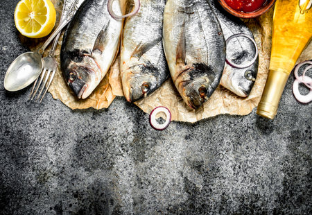 Fresh Dorado with white wine and spices. On a rustic background.の写真素材