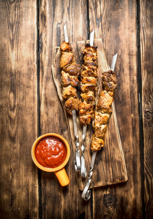 Kebab with tomato sauce. On wooden background.の写真素材