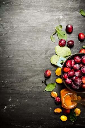 Fresh puree of ripe plums with green leaves. On a black chalkboard.の写真素材