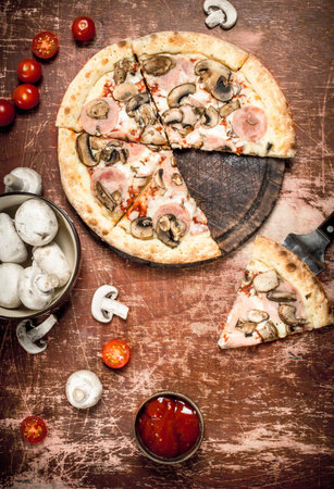 Mushroom pizza with ham. On a rustic background.の写真素材
