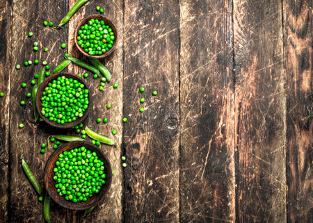 Fresh green peas in a bowl. On a wooden background.の写真素材