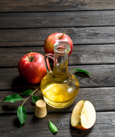 Apple cider vinegar with fresh apples. On wooden background.の写真素材