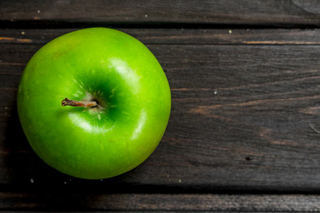 Green fresh Apple. On wooden background