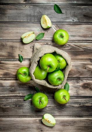 Juicy green apples in an old bag. On gray wood background.の写真素材