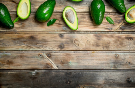 Tasty whole avocado and avocado slices. On a brown wooden background.の写真素材