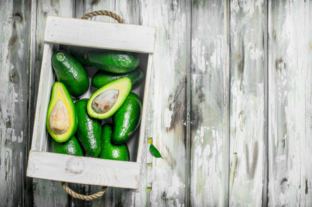 Avocado in a white box. On a white wooden background.の写真素材