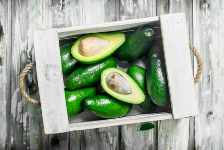 Avocado in a white box. On a white wooden background.の写真素材