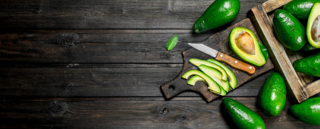 Pieces of avocado and avocado on a dressing. On a black wooden background.の写真素材