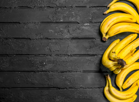 Whole fresh bananas. On black rustic background.の写真素材