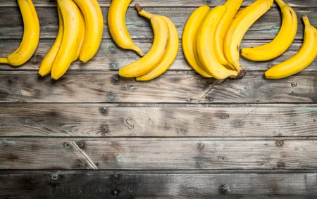 Lots of fresh aromatic bananas. On a black wooden background.の写真素材