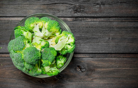 Broccoli in a bowl. On a wooden background.の写真素材