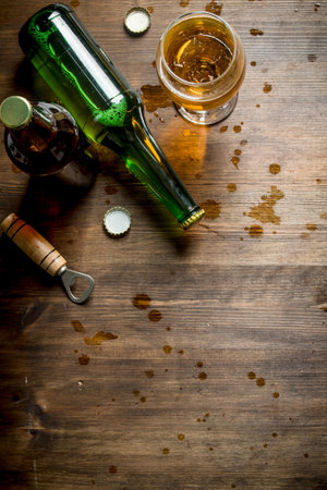 Beer and beer drops. On wooden backgroundの写真素材