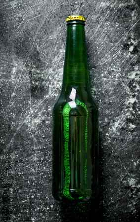 One closed glass bottle of beer. On black rustic backgroundの写真素材